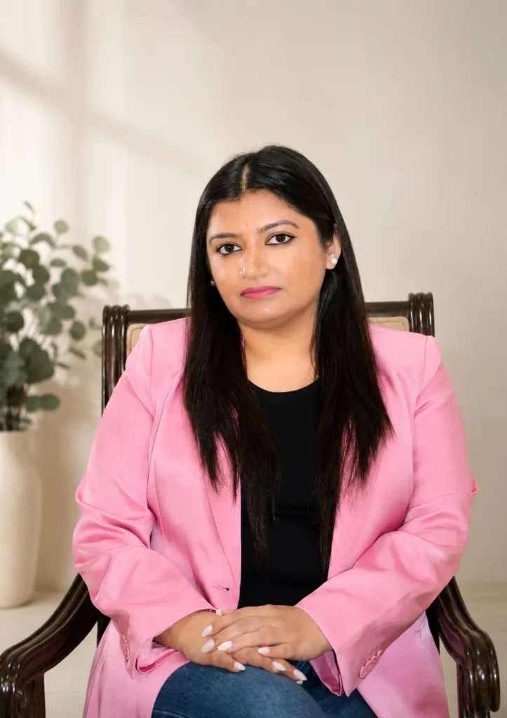 Portrait of Rupeka in a pink blazer, hands gently folded